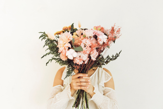 Anonymous Woman Hiding Face behind Flowers